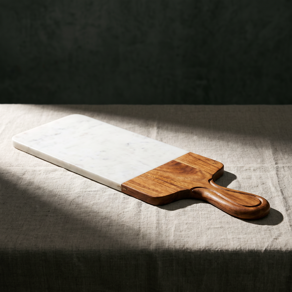 Marble and mango wood serving board with carved handle on table