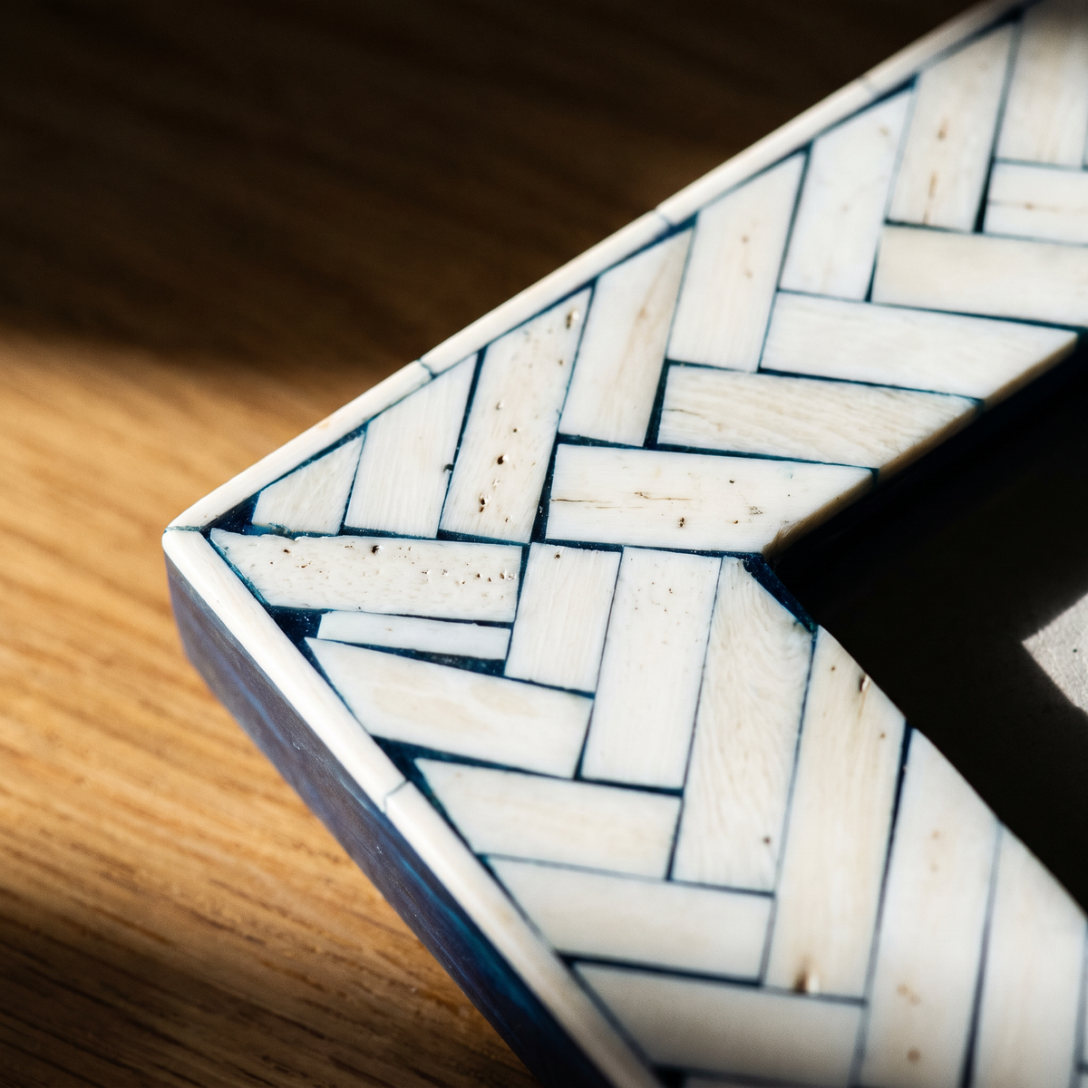 Close-up detail of herringbone bone inlay in indigo frame